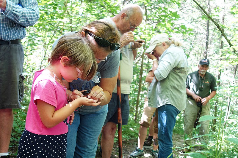 Participants in a guided hike last year at Graham Cave State Park examine their finds.