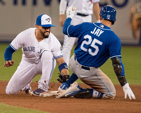 Jon Jay of the Royals slides safely into second with a double under the tag attempt by Devon Travis of the Blue Jays during the second game of Tuesday's doubleheader in Toronto.