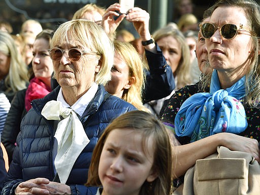 Women wearing pussy - bow ties as a large crowd gathers in the Stortorget square in Stockholm, while the Swedish Academy held its usual Thursday meeting at the Old Stock Exchange building on Thursday April 19, 2018. The crowd have gathered to show their support for former Academy member and Permanent Secretary Sara Danius who stepped down wearing her hallmark, a pussy bow last Thursday. (Jonas Ekströmer / TT via AP)