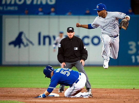 Russell Martin of the Blue Jays slides safely into second base as Royals shortstop Alcides Escobar leaps out of the way during the third inning of Wednesday afternoon's game in Toronto.