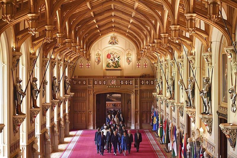 Britain's Prime Minister Theresa May leads other leaders of the Commonwealth nations through St George's hall at Windsor castle, during the CHOGM Commonwealth Heads of Government Meeting, Windsor, England, Friday April 20, 2018. Leaders from the 53-nation Commonwealth nations are meeting in Windsor Castle Friday, without official agenda but are widely expected to discuss protecting the world's oceans, cybersecurity and who should become the next leader of the Commonwealth. (Ben Stansall/PA via AP)