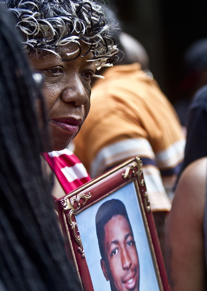 FILE - In this July 7, 2015 file photo, Gwen Carr holds a picture of her son, Eric Garner, during a news conference with relatives of New Yorkers killed by police, outside New York Gov. Andrew Coumo's office in New York. Federal civil rights prosecutors have recommended charging a New York police officer in the 2014 death of Eric Garner. But it’s unclear if that will happen. That’s according to a person familiar with the case who spoke to The Associated Press on condition of anonymity.  (AP Photo/Bebeto Matthews)