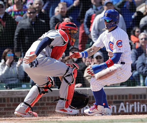 Javier Baez of the Cubs scores past Cardinals catcher Yadier Molina off a single by Anthony Rizzo during the second inning of Thursday afternoon's game in Chicago.