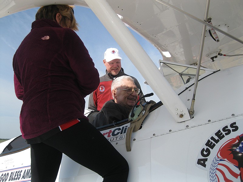 Darryl Fisher, pilot of a 1942 Boeing Stearman military pilot primary training airplane from World War II, and Natalie Habenicht, with Sports Clips Haircuts, help former U.S. Air Force Sgt. Harry Fratesi, 84, into the vintage Stearman at Texarkana Regional Airport during a special flying event for senior adults Saturday. Fratesi was just one of eight senior adults who flew in the Stearman. 
