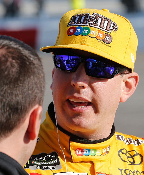 Kyle Busch talks to a member of his crew prior to qualifying Friday for a NASCAR Cup Series race at Richmond Raceway in Richmond, Va.