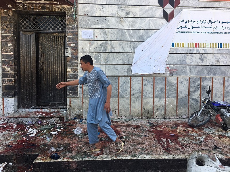 An Afghan man walks outside a voter registration center,  which was attacked by a suicide bomber in Kabul, Sunday, April 22, 2018. (AP Photo/ Rahmat Gul)