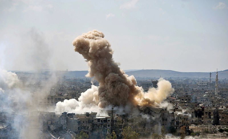 In this photo released by the Syrian official news agency SANA, smoke rises after Syrian government airstrikes and shelling hit in Hajar al-Aswad neighborhood held by Islamic State militants, southern Damascus, Syria, Sunday, April 22, 2018. Syrian state media says government forces are pounding districts of southern Damascus held by Islamic State militants with warplanes, helicopters and artillery in a bid to enforce an evacuation deal reached earlier in the week. (SANA via AP)