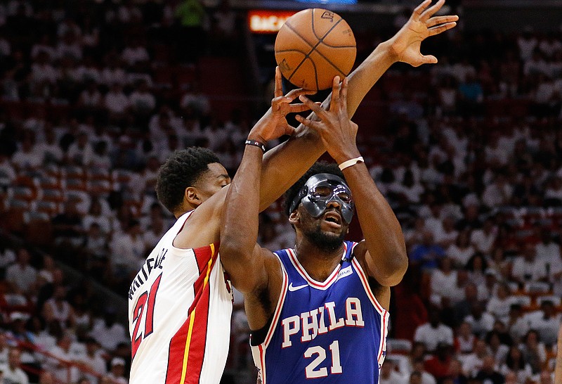 Philadelphia 76ers center Joel Embiid (21) and Miami Heat center Hassan Whiteside (21) battle for a loose ball in the first quarter in Game 4 of a first-round NBA basketball playoff series, Saturday, April 21, 2018, in Miami. (AP Photo/Joe Skipper)