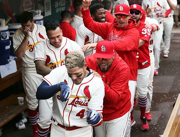 Cardinals catcher Yadier Molina leads a conga line of teammates celebrating in the dugout after he hit a go-ahead solo home run in the seventh inning against the Reds in Saturday afternoon's game in St. Louis.