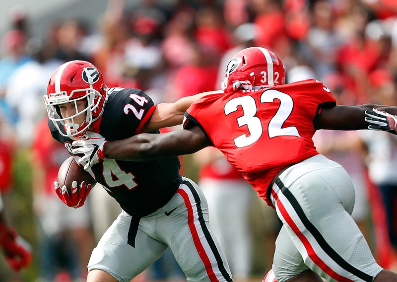 Georgia running back Prather Hudson (24) tries to breaks free from Monty Rice (32) during the first half of the G Day inter squad spring football game Saturday, April 21, 2018, in Athens, Ga. (AP Photo/John Bazemore)