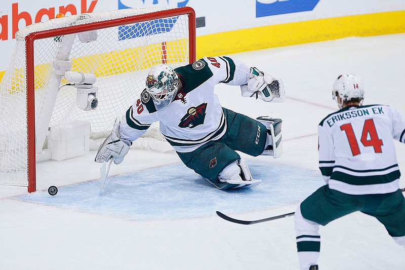 Minnesota Wild goaltender Devan Dubnyk (40) scrambles for a puck that bounced off his leg during the first period in Game 5 of the team's NHL hockey first-round playoff series against the Winnipeg Jets in Winnipeg, Manitoba, Friday, April 20, 2018. (John Woods/The Canadian Press via AP)