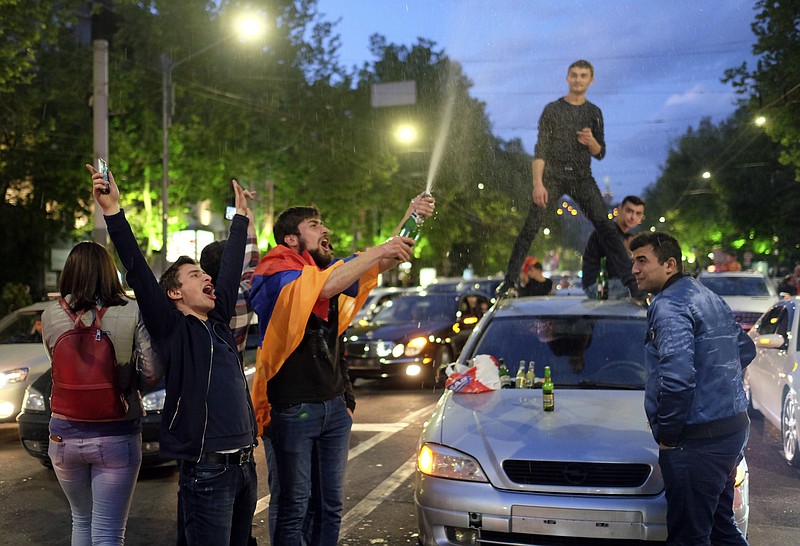 People celebrate Armenian Prime Minister's Serzh Sargsyan's resignation in Republic Square in Yerevan, Armenia, Monday, April 23, 2018. Sargsyan resigned unexpectedly Monday to quell massive anti-government protests over what critics feared was his effort to seize power for life. (Hrant Khactaryan/PAN Photo via AP)