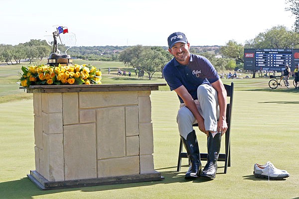 Andrew Landry puts on boots given to the winner of the Valero Texas Open after the final round Sunday in San Antonio.