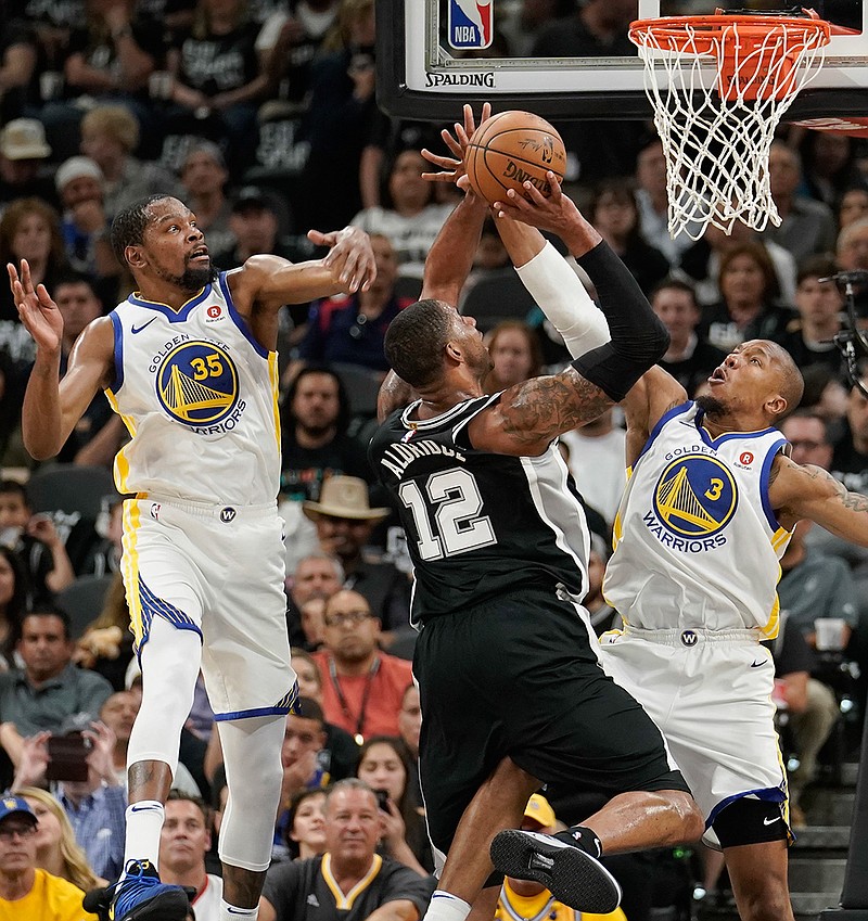 San Antonio Spurs' LaMarcus Aldridge shoots against Golden State Warriors' David West and Kevin Durant during the first half of Game 4 of a first-round NBA playoff series Sunday in San Antonio.