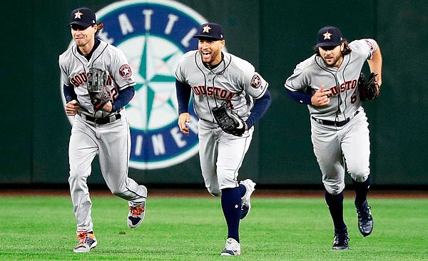 Astros outfielders (from left) Josh Reddick, George Springer and Jake Marisnick race to the infield after a win earlier this season against the Mariners in Seattle. Houston outfielders have been celebrating victories this season by doing dances inspired by the Fortnite Battle Royale video game.