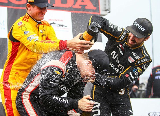 Second-place finisher Ryan Hunter-Reay (left) and third-place finisher James Hinchcliffe (right) spray champagne Monday on winner Josef Newgarden after the Indy Grand Prix of Alabama in Birmingham, Ala.