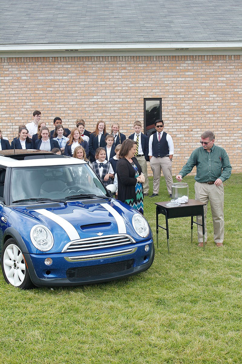 Students at Veritas Academy watch Monday as the school's accountant, Troy Lemons, draws a name in a raffle to win a 2006 Mini Cooper. The school bought the car to raise money for students needing tuition assistance. It's the second year for the drawing, with last year's raffle featuring a 1999 Porsche Boxster Turbo.