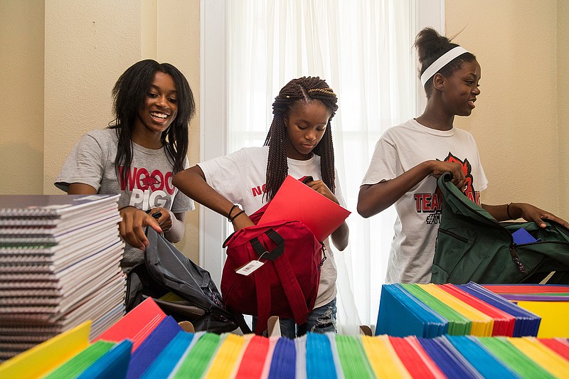 Jayda Griffin, Taylor Wilkerson and Lois Wimsatt pack backpacks with school supplies July 25, 2016, at the offices of The Healing Place on Ferguson Street in Texarkana, Ark. The community service organization is closing its headquarters and instead will send volunteers to provide help where they are needed.