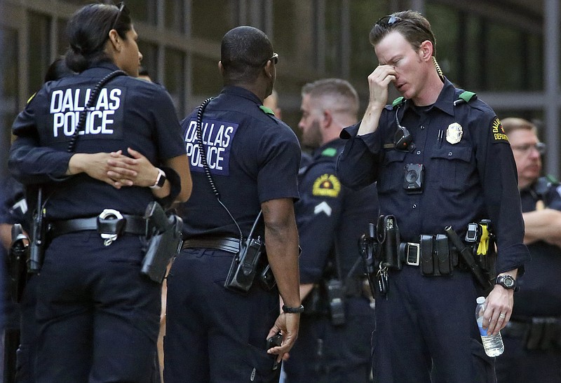 Dallas Police officers wait outside the entrance of the emergency room at Presbyterian Hospital, Tuesday, April 24, 2018, in Dallas, following a shooting at an area Home Depot where two police officers and a civilian were shot. The officers were critically wounded in the shooting, according to officials. (Louis DeLuca/The Dallas Morning News via AP)