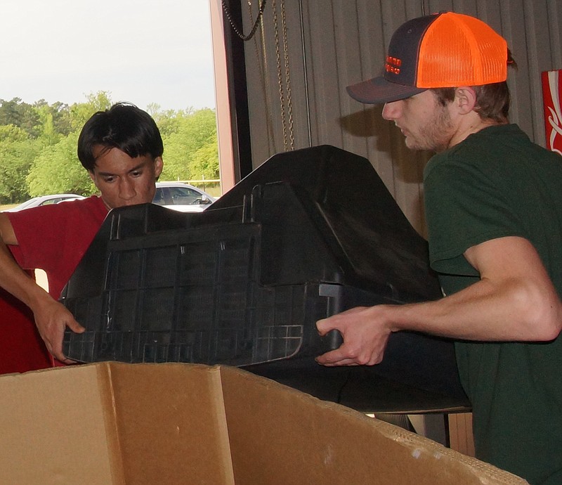 Mitchell Winders, left, and Robert Wimberly load a large television onto a tractor-trailer Saturday at Guard-Line in Atlanta. Their effort was part of E-Waste Day.