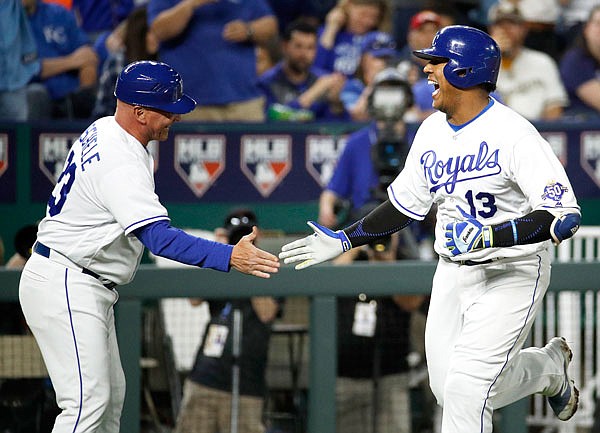 Royals catcher Salvador Perez celebrates with third base coach Mike Jirschele after hitting a solo home run during the fourth inning of Tuesday's game against the Brewers in Kansas City.