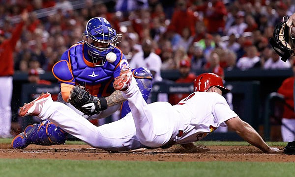 Paul DeJong of the Cardinals scores past Mets catcher Jose Lobaton during the fourth inning of Wednesday night's game at Busch Stadium.