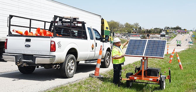 Jeff Hughes of Traffic Control Company in St. Louis sets up a message board Monday, April 30, 2018 along U.S. 54 in Jefferson City. This unit contains radar which will measure traffic speed and encourage motorists to drive at a safe rate in the construction zone.