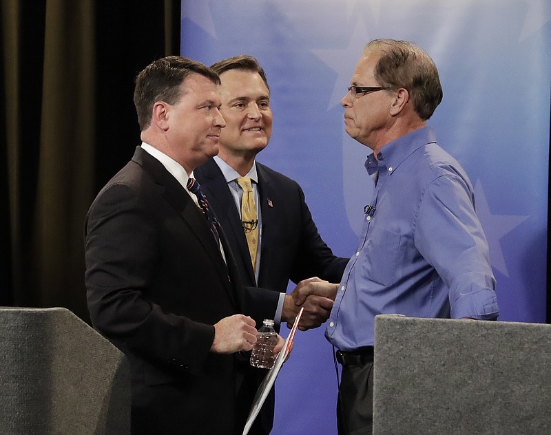 In this April 30, 2018, photo, Senate candidates from left, Todd Rokita, Luke Messer and Mike Braun speak with each other following the Indiana Republican senate primary debate in Indianapolis. As primary season kicks into high gear, Republicans are engaged in nomination fights that are pulling the party to the right, leaving some leaders worried their candidates will be out of a step with the broader electorate in the November election. (AP Photo/Darron Cummings, Pool)