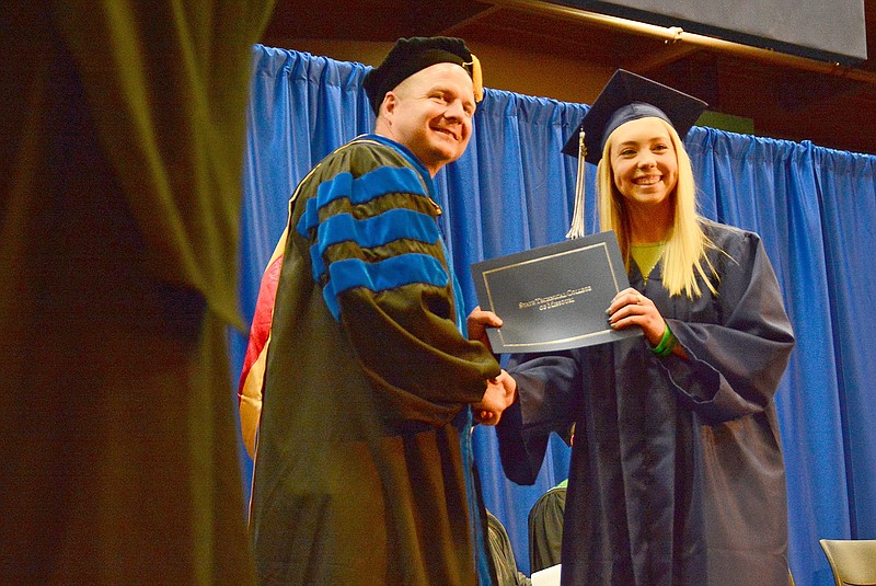 Cory Hentges, right, receives her automotive collision certificate Saturday during graduation at Linn State Technical College in Linn. Hentges grew up in Jefferson City.