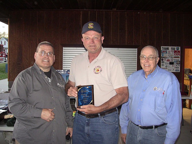 Fulton Fire Department's Capt. Carl Stassel, center, has been named the Fulton employee of the year. He was recently presented with a plaque by City Administrator Bill Johnson, left, and Mayor LeRoy Benton, right, at the annual city employee picnic. 