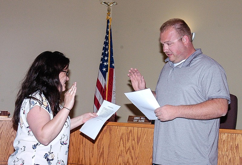 City Clerk Aimee Hill, left, administers the oath of office to new Ward I Councilman Aaron Grimes on May 7. Grimes was selected to fill the position following the election in which no one filed for the seat.