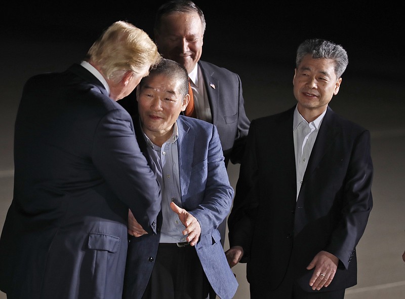 President Donald Trump, accompanied by Secretary of State Mike Pompeo, back, shakes hands with former North Korean detainees Kim Dong Chul, with Kim Hak Song, upon their arrival, Thursday, May 10, 2018, at Andrews Air Force Base, Md. (AP Photo/Alex Brandon)