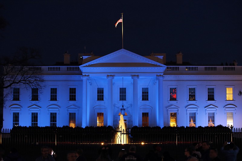 FILE - In this April 2, 2017, file photo, the White House is lit with blue lights in honor of World Autism Awareness Day in Washington. Top U.S. tech executives and researchers are gathering at a White House summit, Thursday, May 10, 2018, to press Trump administration officials on investing in artificial intelligence and crafting policies they hope will strengthen the economy without displacing jobs. (AP Photo/Alex Brandon, File)