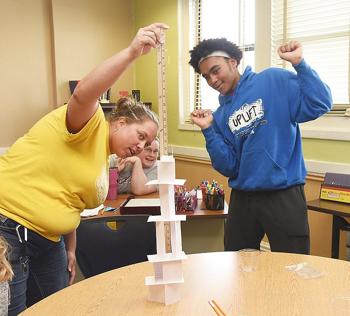 In this April 4, 2018 photo, Jefferson City Academic Center junior Nate Dickinson reacts to his team winning the tallest structure contest as Katte Distler records a height of 21 inches. Students from JCAC once again performed a day of community service, which over the years is estimated to have donated the equivalent of over $40,000 of paid work back to non-profit organizations in the immediate area. After working, they returned to the school for games that required using their knowledge and team building skills to solve the prescribed problem. 