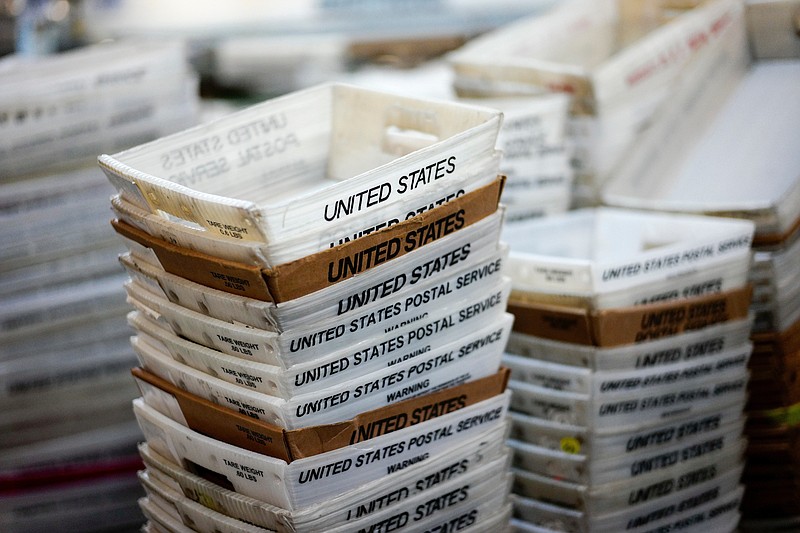 FILE- In this Dec. 14, 2017, file photo, boxes for sorted mail are stacked at the main post office in Omaha, Neb.  The U.S. Postal Service is reporting another quarterly loss after an unrelenting decline in mail volume and costs of its health care and pension obligations overcame strong gains in package deliveries.  (AP Photo/Nati Harnik, File)