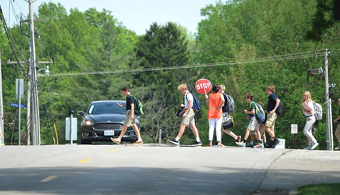 St. Joseph Cathedral students head home May 3, 2018, crossing the street directly in front of the school, under the watchful eye of a crossing guard.