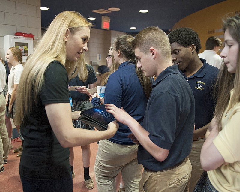 Jenni Kuzubova, a brand ambassador for the "It Can Wait" campaign," speaks Friday to Kaleb Bish, center, and other students at Helias Catholic High School.