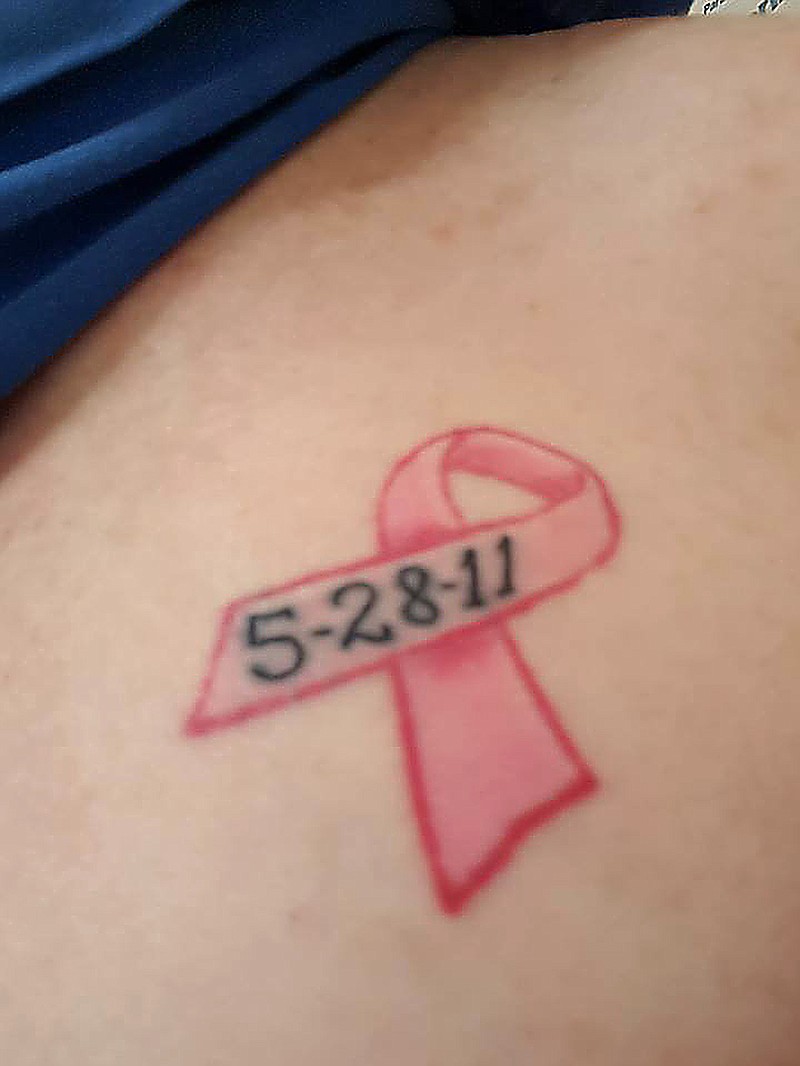 
Debra Smulders shows her first tattoo on her chest which symbolizes her battle with breast cancer. 