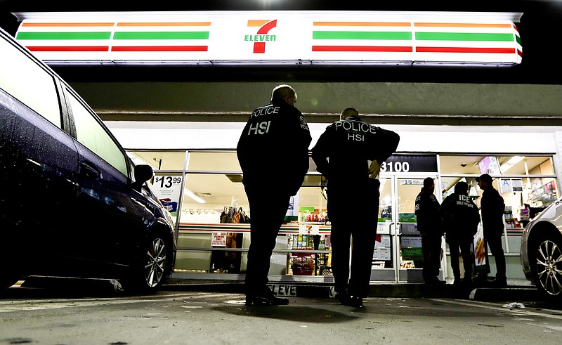 FILE - In this Jan. 10, 2018, file photo U.S. Immigration and Customs Enforcement agents serve an employment audit notice at a 7-Eleven convenience store in Los Angeles. Immigration officials have sharply increased audits of companies to verify that their employees are authorized to work in the country, signaling the Trump administration's crackdown on illegal immigration is reaching deeper into the workplace to create a "culture of compliance" among employers who rely on immigrant labor. (AP Photo/Chris Carlson, File)