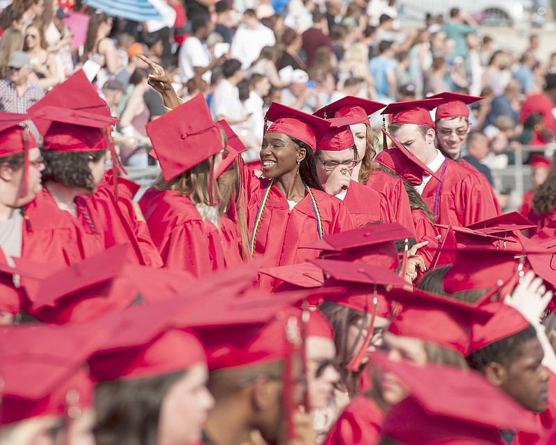 Members of the Jefferson City High School graduating class wave to family and friends Sunday as they take their seats at the start of the commencement exercise at Adkins Football Stadium.