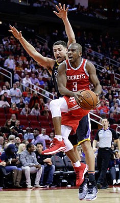 In this Jan. 20 file photo, Chris Paul of the Rockets shoots in front of Klay Thompson of the Warriors during a game in Houston.