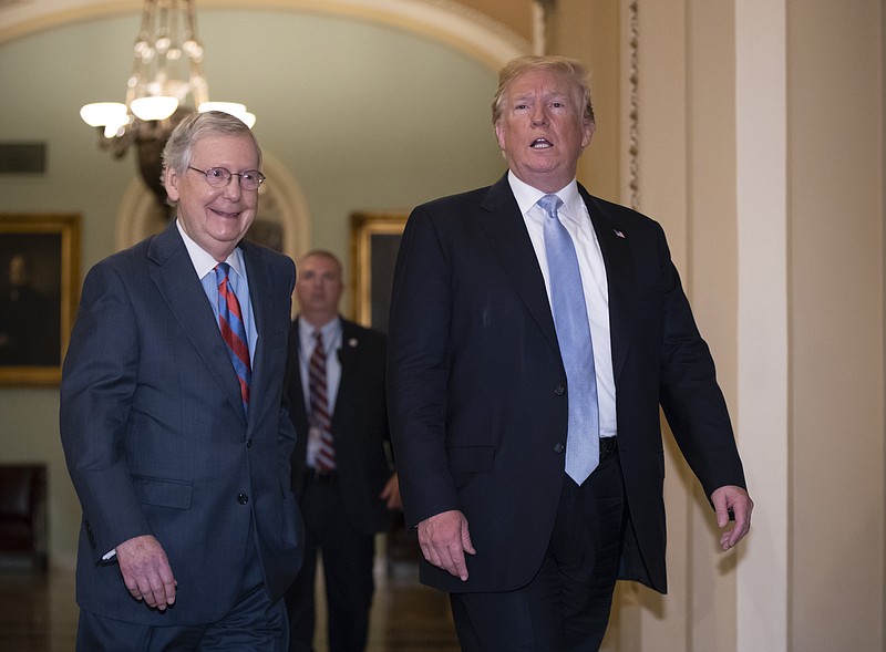 President Donald Trump walks with Senate Majority Leader Mitch McConnell, R-Ky., left, to a closed-door meeting with Senate Republicans at the Capitol in Washington, Tuesday, May 15, 2018. (AP Photo/J. Scott Applewhite)