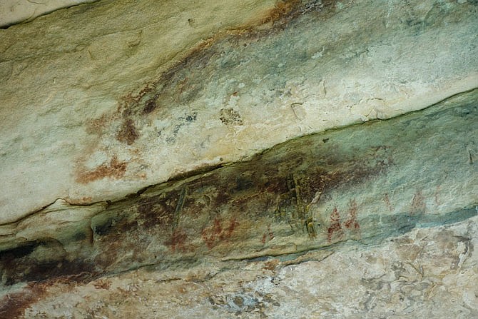 Red marks on the second-to-the-bottom layer of strata are ancient graffiti, left behind by ancient people in the area of Graham Cave.