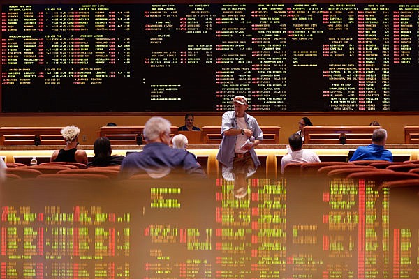 People sit in the sports book Monday at the South Point hotel-casino in Las Vegas. 