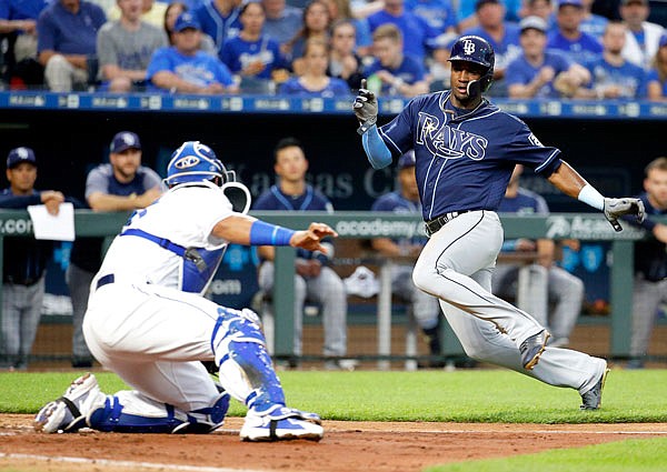 Adeiny Hechavarria of the Rays tries to avoid the tag by Royals catcher Salvador Perez during the sixth inning of Monday's game in Kansas City. Hechavarria was safe on the play, scoring the go-ahead run in the Rays' 2-1 win.