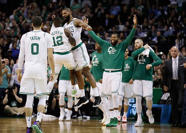 Celtics guard Terry Rozier (12) and forward Marcus Morris leap in celebration near the end of Tuesday's Game 2 of NBA Eastern Conference finals against the Cavaliers in Boston.