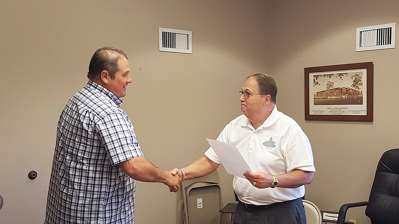 Larry Vincent, chairman of the Jefferson City Housing Authority Board of Commissioners, presents Sgt. Joe Matherne with a resolution Tuesday, thanking him for his work with the Housing Authority.