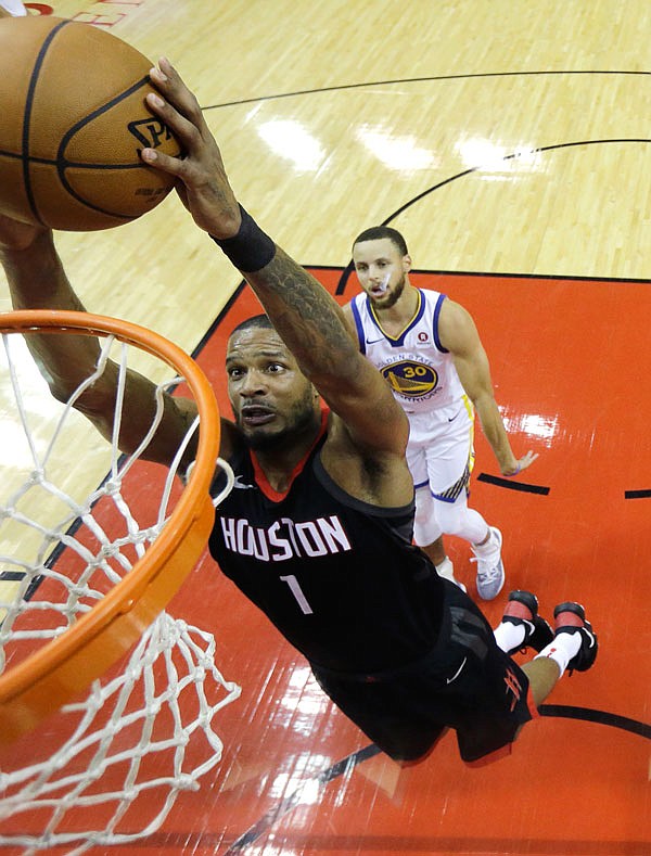 Rockets forward Trevor Ariza scores past Warriors guard Stephen Curry during the first half of Game 2 of the Western Conference Finals on Wednesday night.