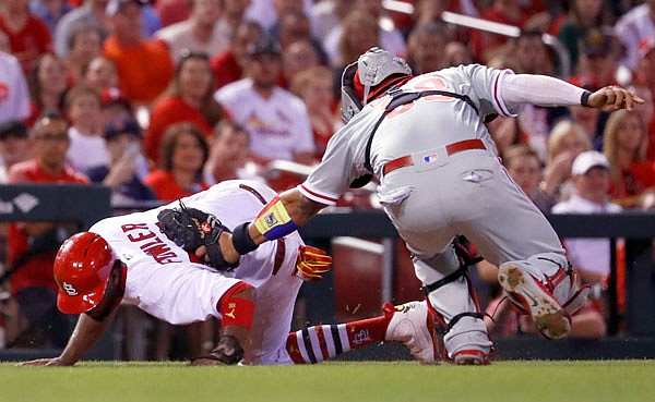 Dexter Fowler of the Cardinals is tagged out by Phillies catcher Jorge Alfaro after being caught between third and home during the seventh inning of Thursday's game in St. Louis.