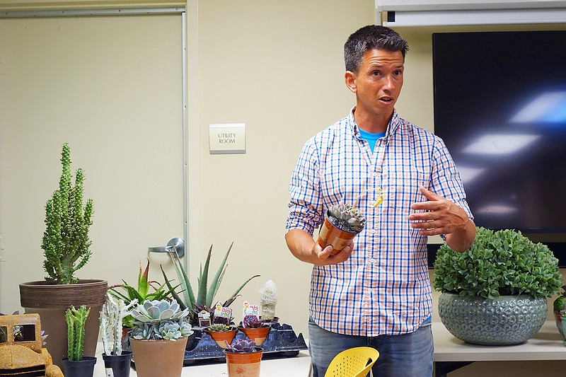 John Graham, owner of Callaway Fields, holds a happily blooming echeveria. Graham taught at the library Thursday to show how to care and keep succulents and cactuses healthy.